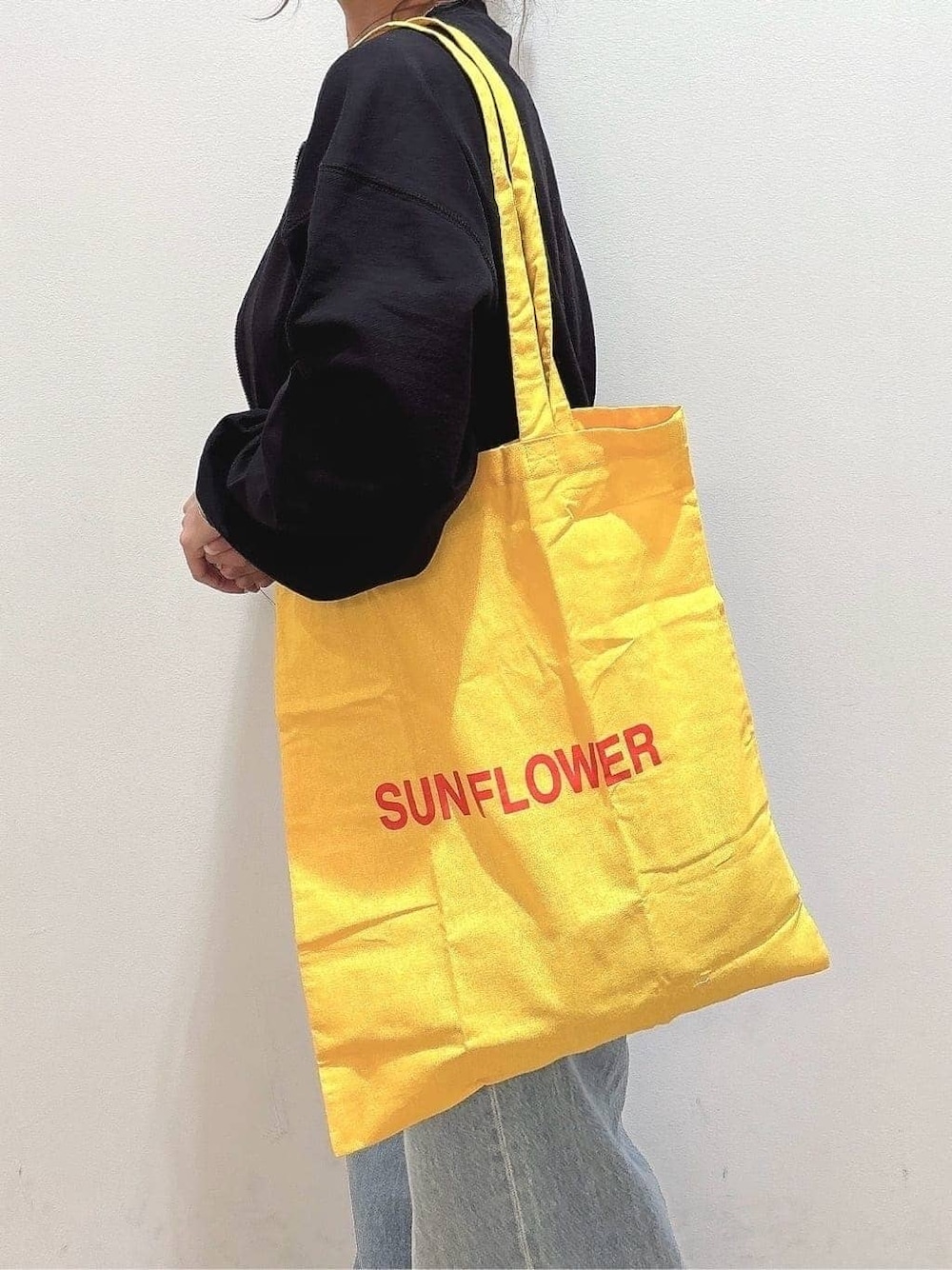 グレー系のTシャツ/カットソー、ブルー系のデニムパンツ、イエロー系のその他を着用したレディースの春コーディネートの7枚目の写真