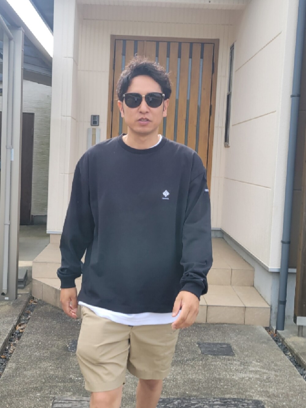 ベージュ系のパンツ、ブラック系のTシャツ/カットソー、ブラック系のスニーカーを着用したメンズの夏コーディネートの4枚目の写真