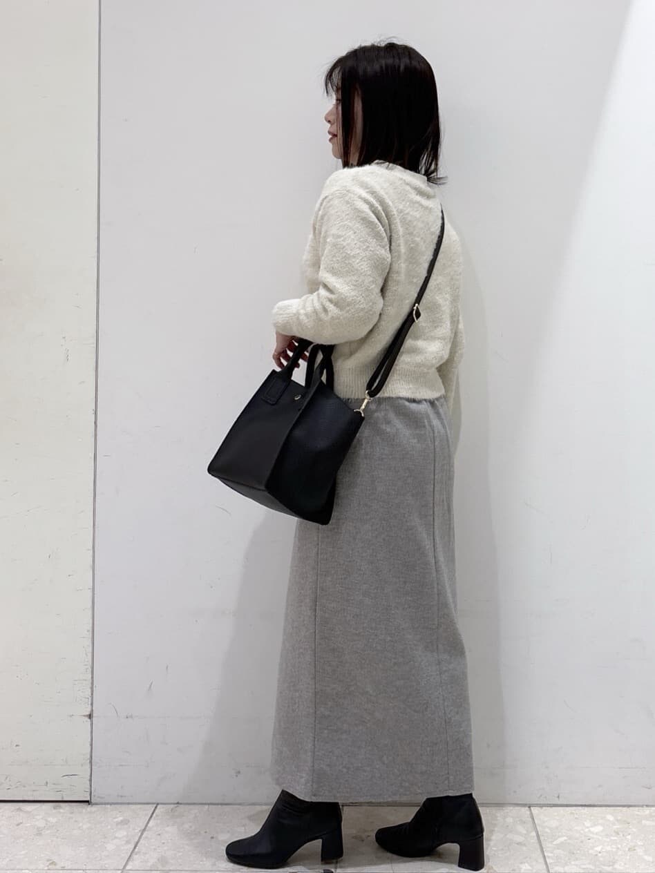 ベージュ系のニット/セーター、グレー系のスカート、ブラック系のショルダーバッグを着用したレディースの冬コーディネートの4枚目の写真