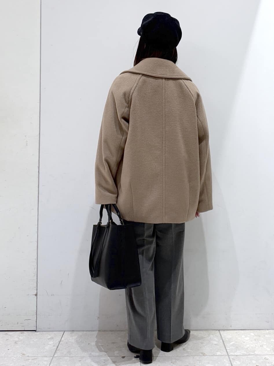 ベージュ系のピーコート、グレー系のニット/セーター、ホワイト系のTシャツ/カットソーを着用したレディースの冬コーディネートの3枚目の写真