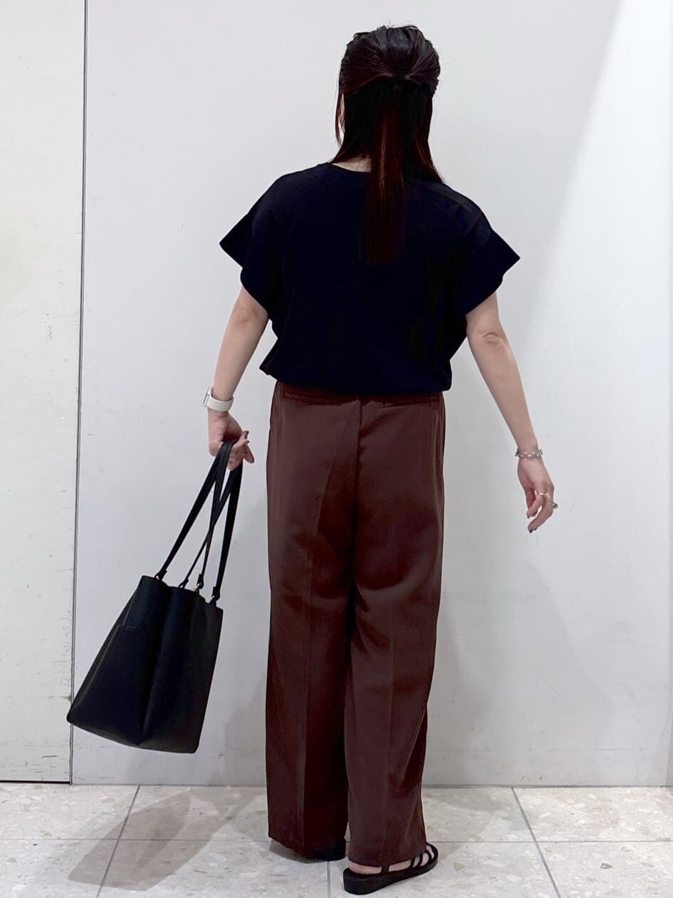ブラック系のニット/セーター、ブラウン系のその他パンツ、ブラック系のトートバッグを着用したレディースの夏コーディネートの3枚目の写真