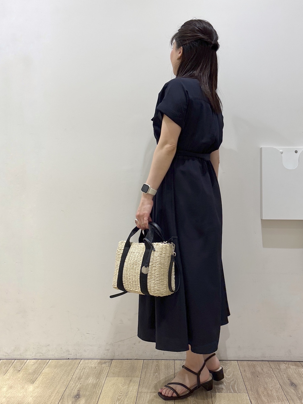 ブルー系のワンピース、ブラック系のトートバッグ、ブラウン系のサンダルを着用したレディースの春コーディネートの4枚目の写真