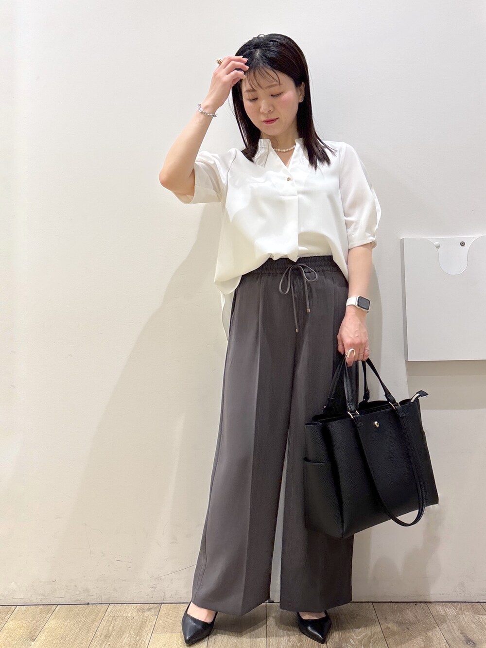ブラック系のトートバッグ、ブラック系のパンプス、ホワイト系のシャツ/ブラウスを着用したレディースの春コーディネートの8枚目の写真