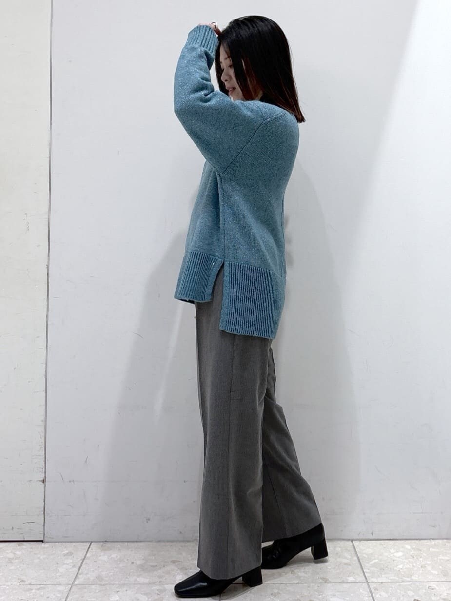 ブルー系のニット/セーター、グレー系のその他パンツ、ブラック系のトートバッグを着用したレディースの冬コーディネートの5枚目の写真