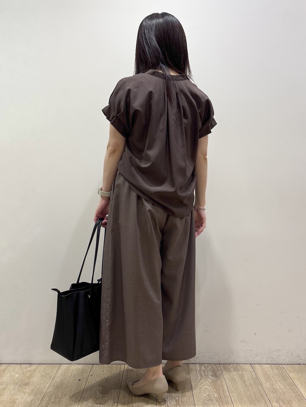 ブラウン系のシャツ/ブラウス、ブラウン系のその他パンツ、ブラック系のトートバッグを着用したレディースの夏コーディネートの3枚目の写真