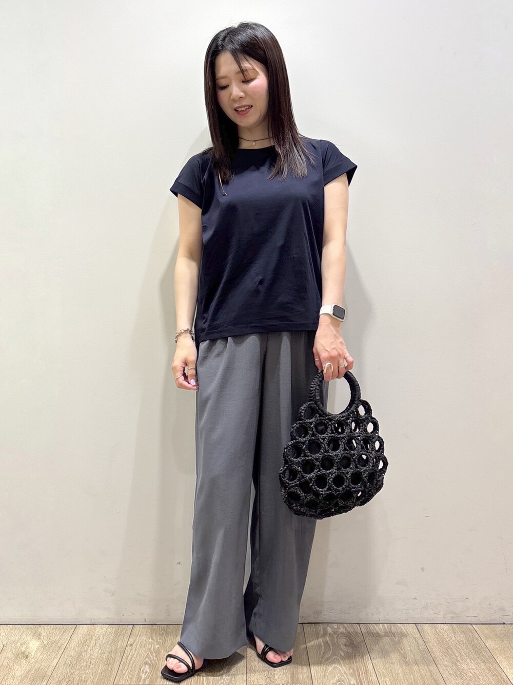 ブルー系のTシャツ/カットソー、グレー系のその他パンツ、ブラック系のハンドバッグを着用したレディースの夏コーディネートの9枚目の写真