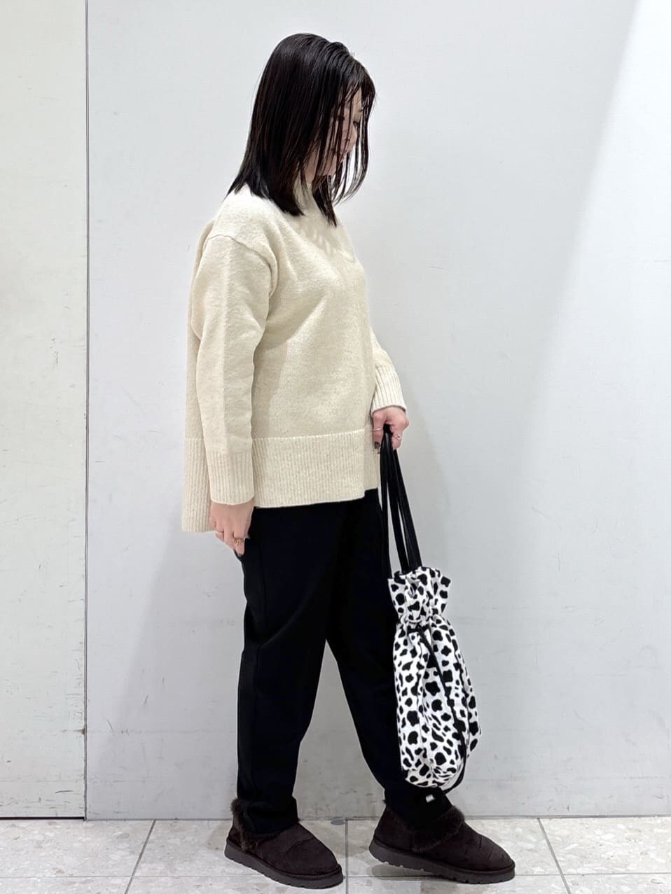 ベージュ系のニット/セーター、ブラック系のその他パンツ、ブラック系のトートバッグを着用したレディースの冬コーディネートの4枚目の写真