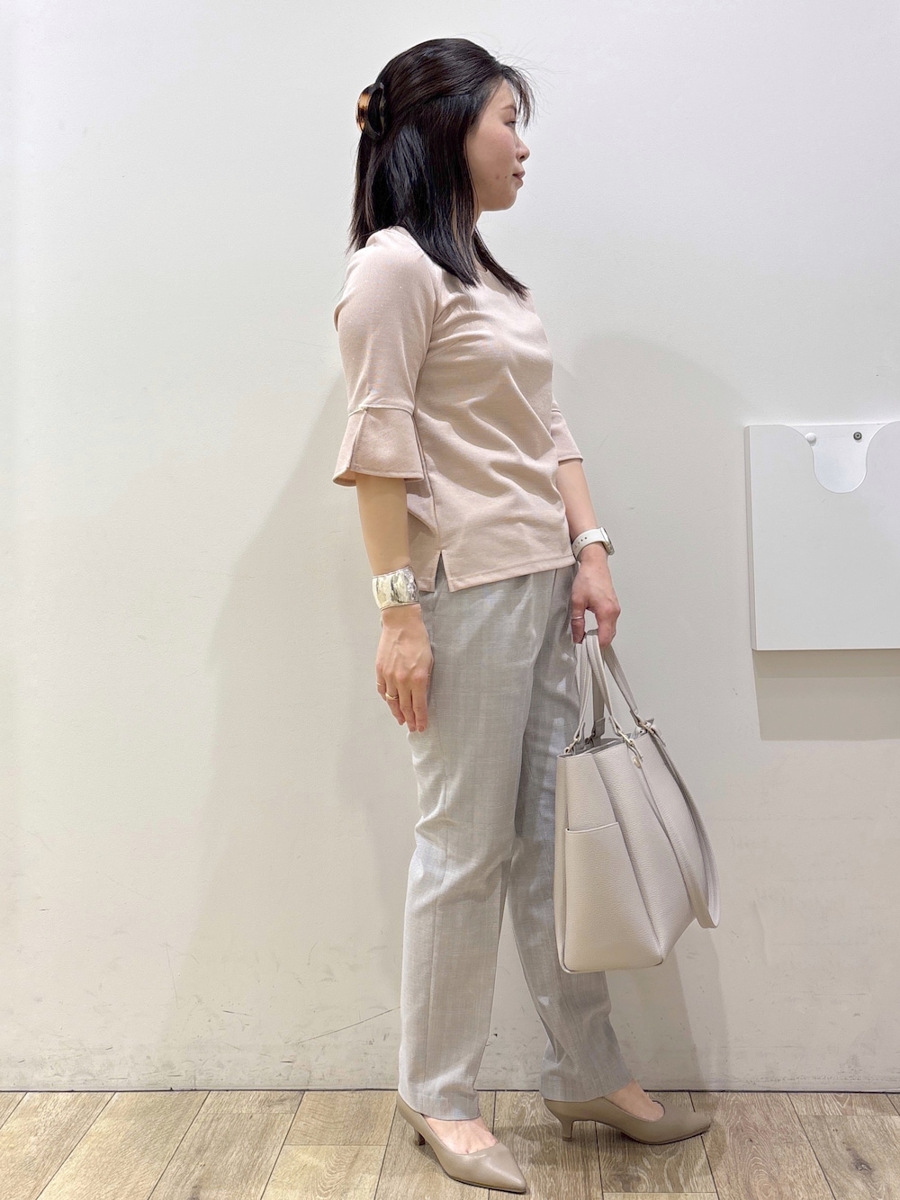 ベージュ系のパンプス、グレー系のカーディガン/ボレロ、ベージュ系のトートバッグを着用したレディースの春コーディネートの2枚目の写真