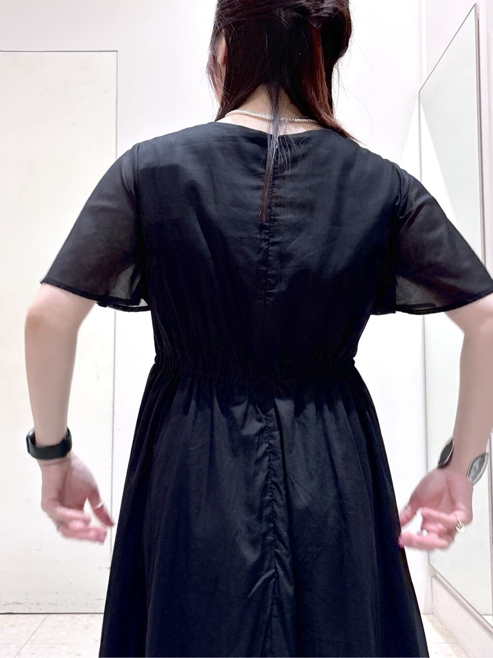ブラック系のワンピース、ブラック系のトートバッグ、ブラック系のパンプスを着用したレディースの夏コーディネートの6枚目の写真