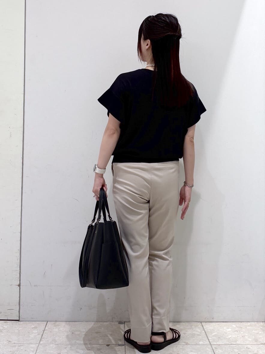 ブラック系のニット/セーター、ベージュ系のその他パンツ、ブラック系のトートバッグを着用したレディースの夏コーディネートの3枚目の写真
