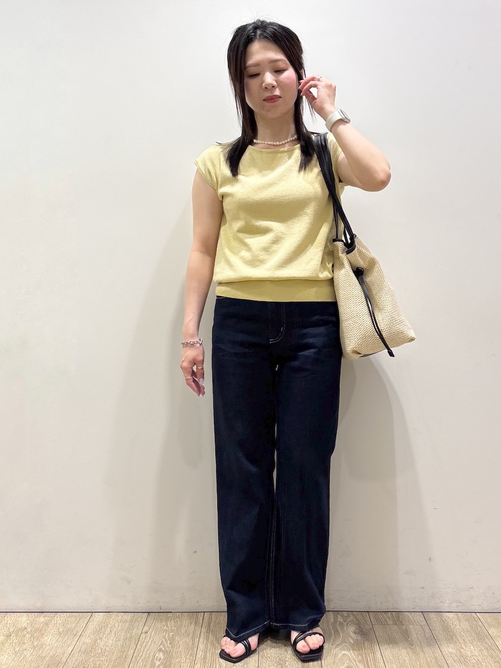 イエロー系のニット/セーター、ブルー系のその他パンツ、ホワイト系のトートバッグを着用したレディースの夏コーディネートの5枚目の写真