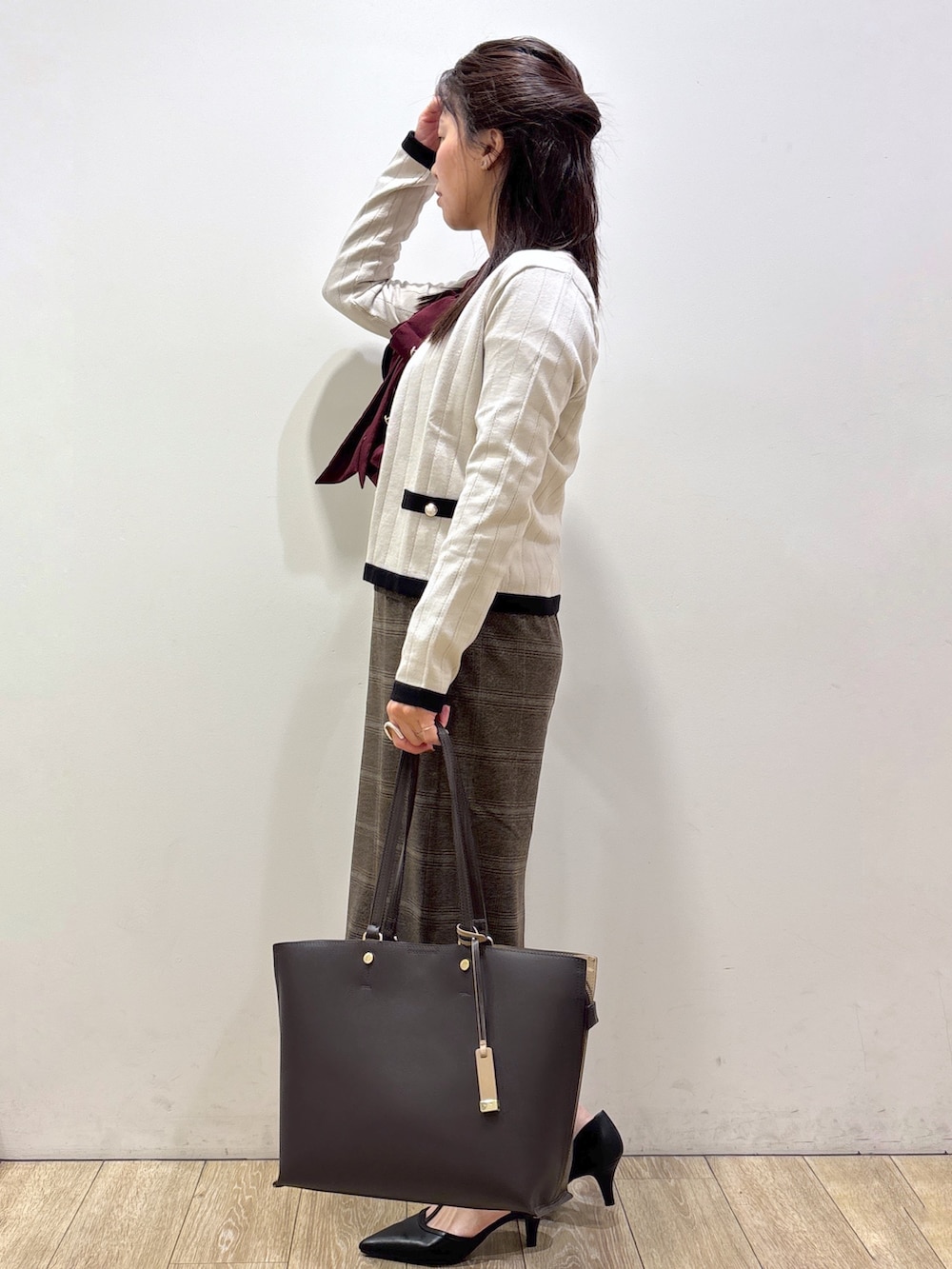 ベージュ系のカーディガン/ボレロ、レッド系のシャツ/ブラウス、ブラウン系のスカートを着用したレディースの秋コーディネートの4枚目の写真