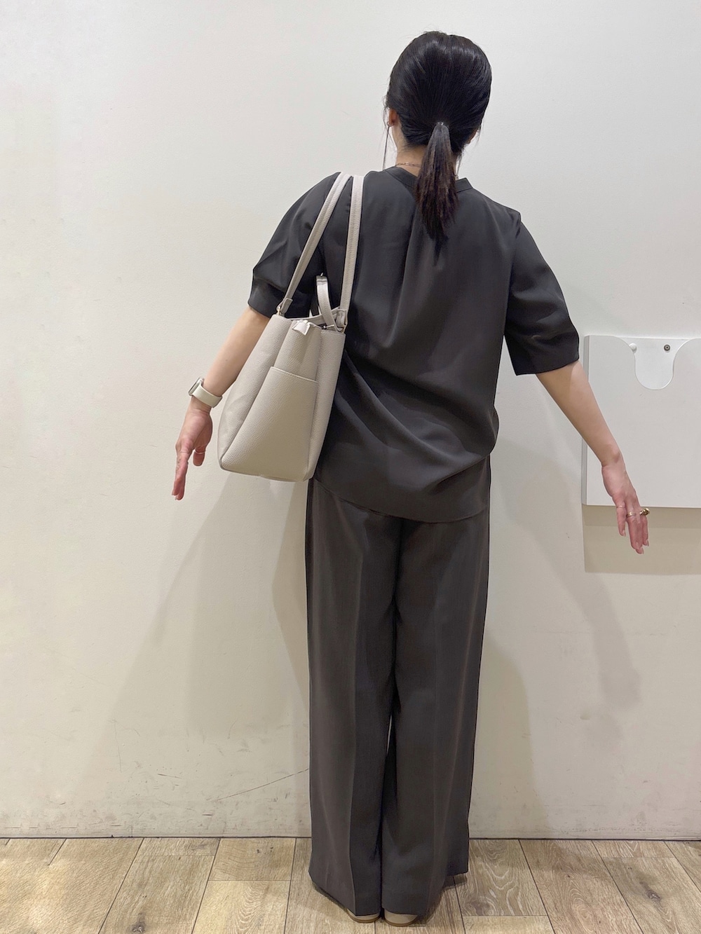 ベージュ系のパンプス、グレー系のカーディガン/ボレロ、ベージュ系のトートバッグを着用したレディースの春コーディネートの7枚目の写真