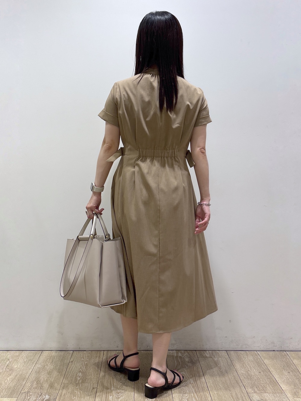 イエロー系のワンピース、ベージュ系のトートバッグ、ブラック系のサンダルを着用したレディースの夏コーディネートの3枚目の写真
