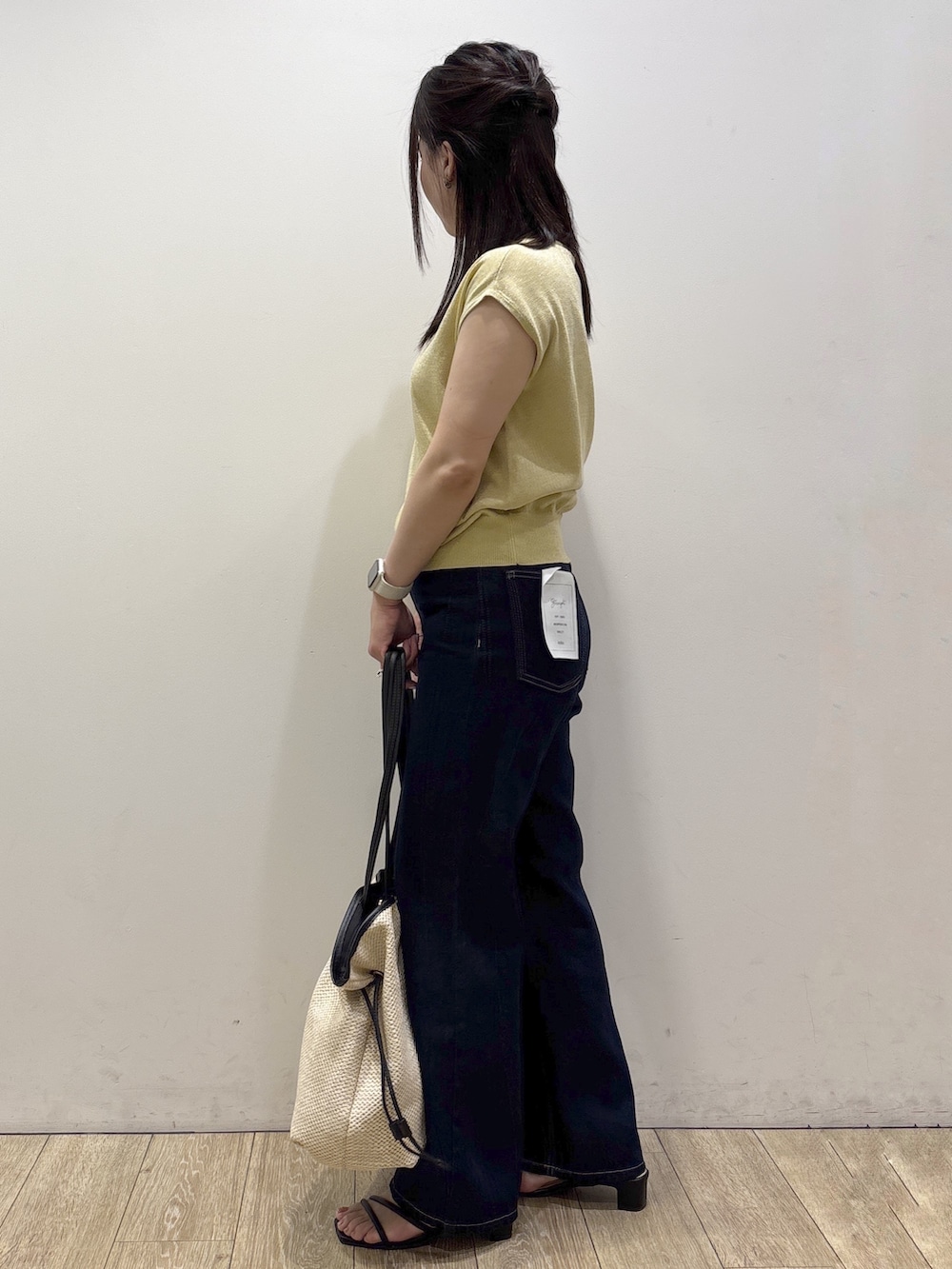 イエロー系のニット/セーター、ブルー系のその他パンツ、ホワイト系のトートバッグを着用したレディースの夏コーディネートの4枚目の写真