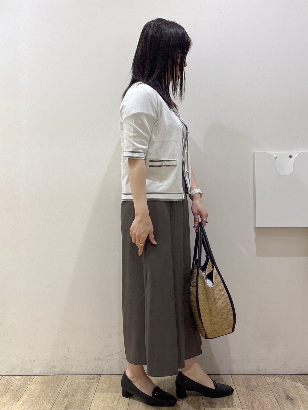 ブラック系のパンプス、ホワイト系のカーディガン/ボレロ、ホワイト系のシャツ/ブラウスを着用したレディースの春コーディネートの2枚目の写真