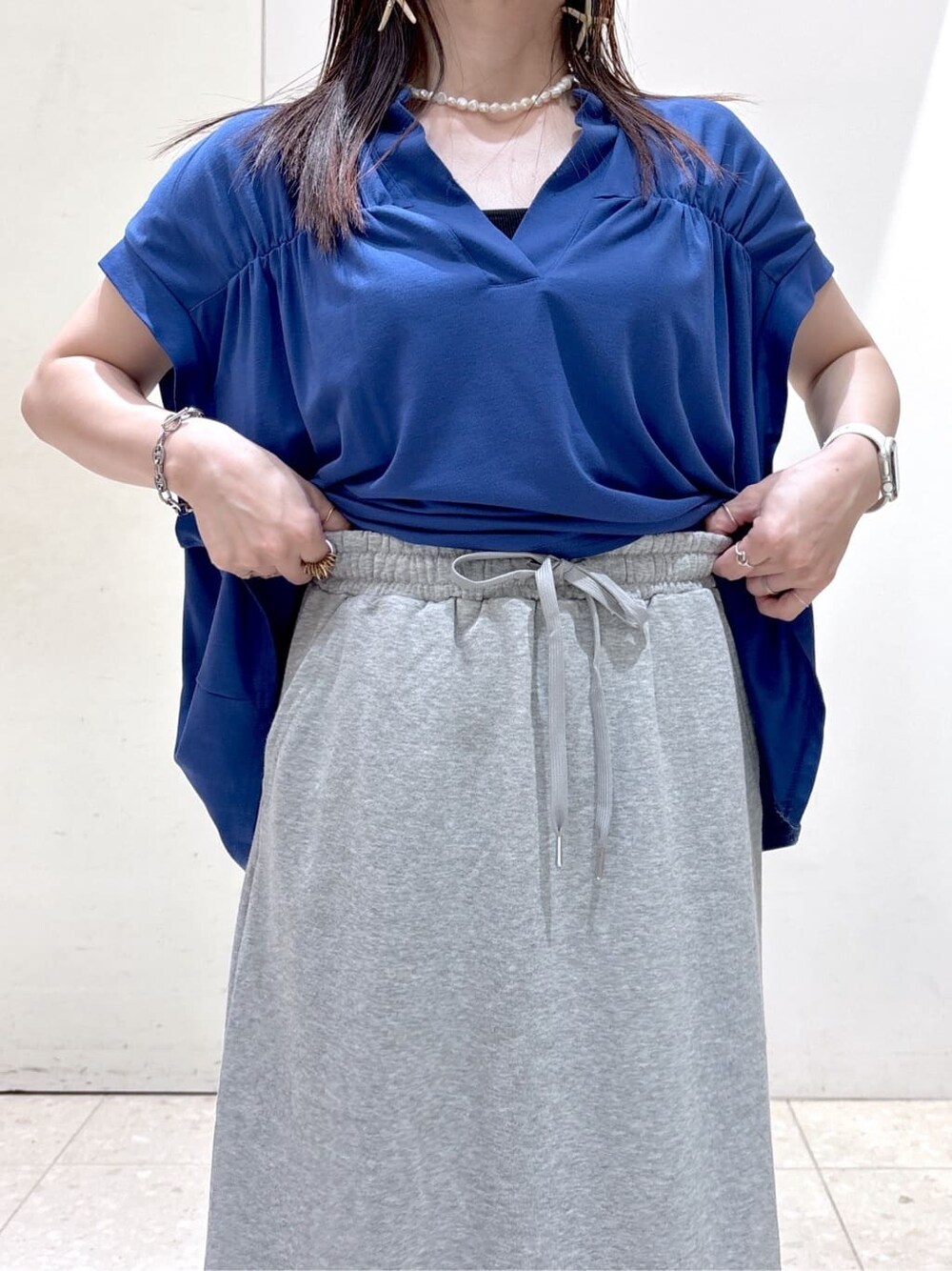 ブルー系のTシャツ/カットソー、グレー系のスカート、ブラック系のトートバッグを着用したレディースの夏コーディネートの8枚目の写真