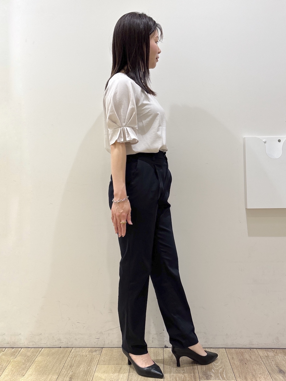 ブラック系のパンプス、グレー系のトートバッグ、ブルー系のその他パンツを着用したレディースの春コーディネートの6枚目の写真