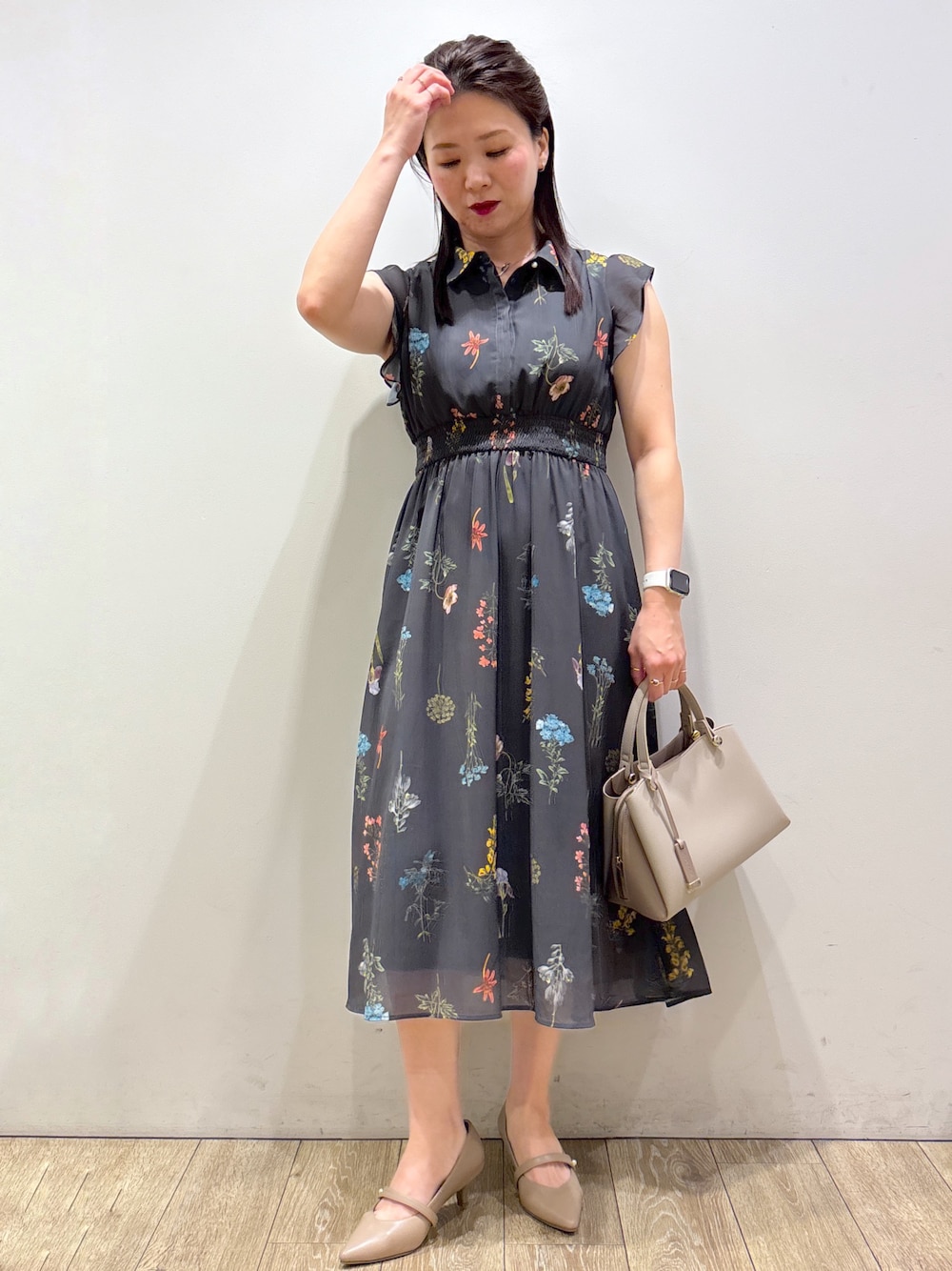 グレー系のワンピース、ベージュ系のボストンバッグ、ベージュ系のパンプスを着用したレディースの夏コーディネートの9枚目の写真