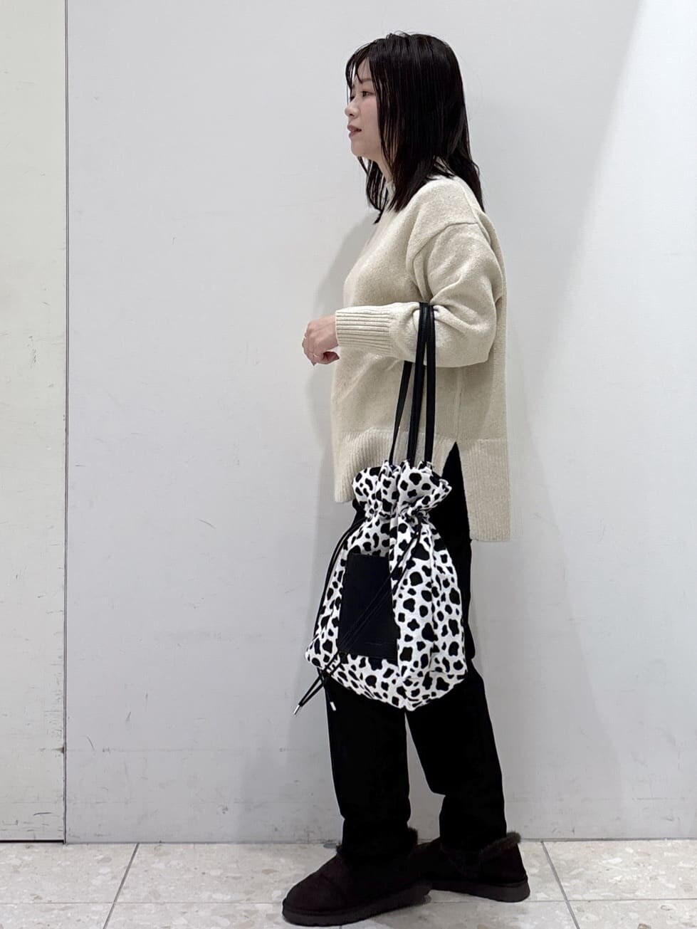 ベージュ系のニット/セーター、ブラック系のその他パンツ、ブラック系のトートバッグを着用したレディースの冬コーディネートの2枚目の写真