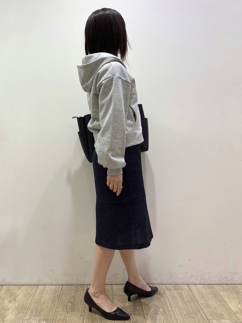 グレー系のパーカー、ホワイト系のシャツ/ブラウス、ブルー系のスカートを着用したレディースの冬コーディネートの2枚目の写真