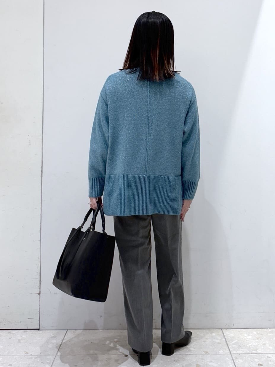 ブルー系のニット/セーター、グレー系のその他パンツ、ブラック系のトートバッグを着用したレディースの冬コーディネートの3枚目の写真