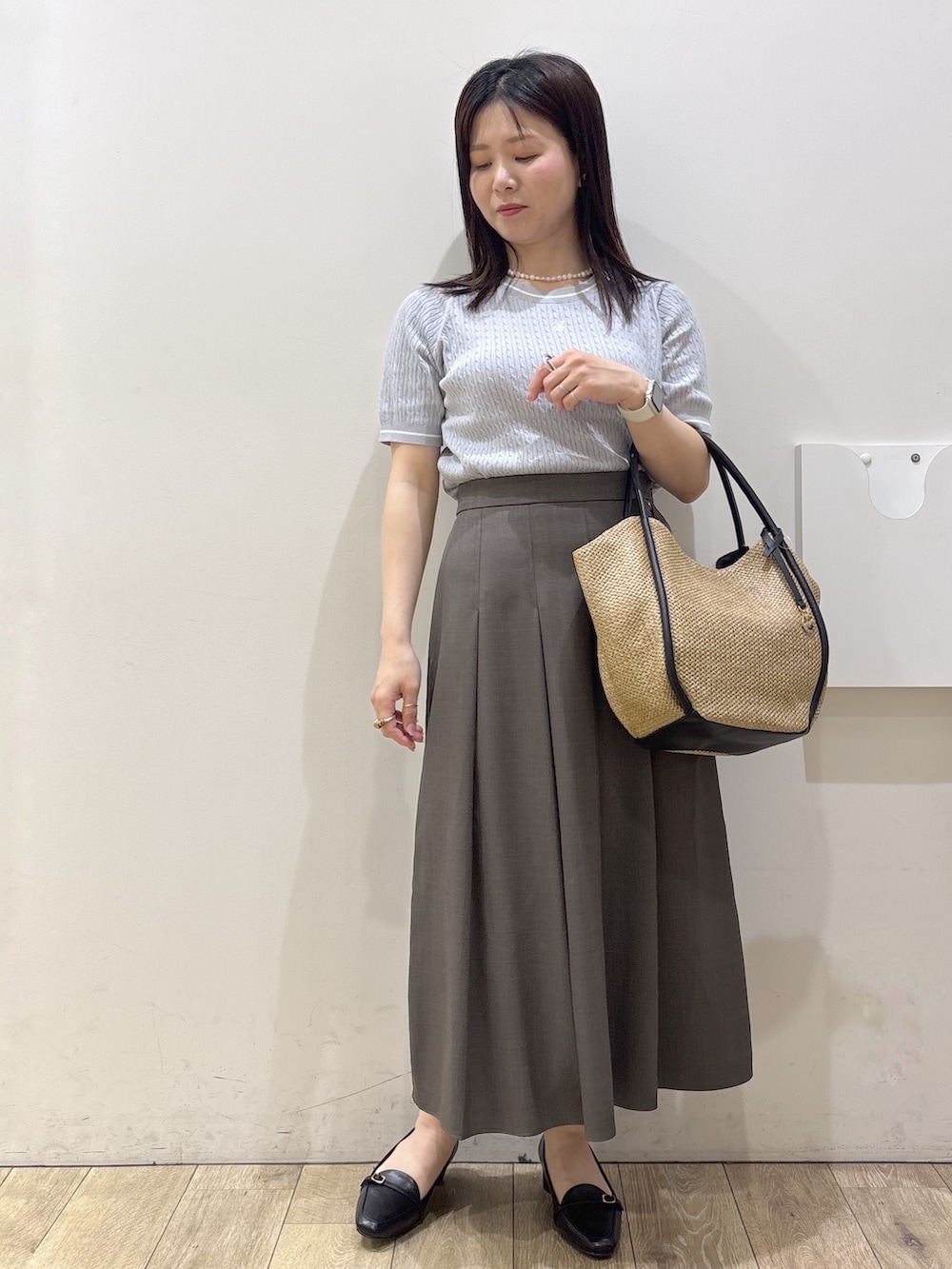ブラック系のパンプス、ホワイト系のシャツ/ブラウス、ブルー系のニット/セーターを着用したレディースの春コーディネートの4枚目の写真