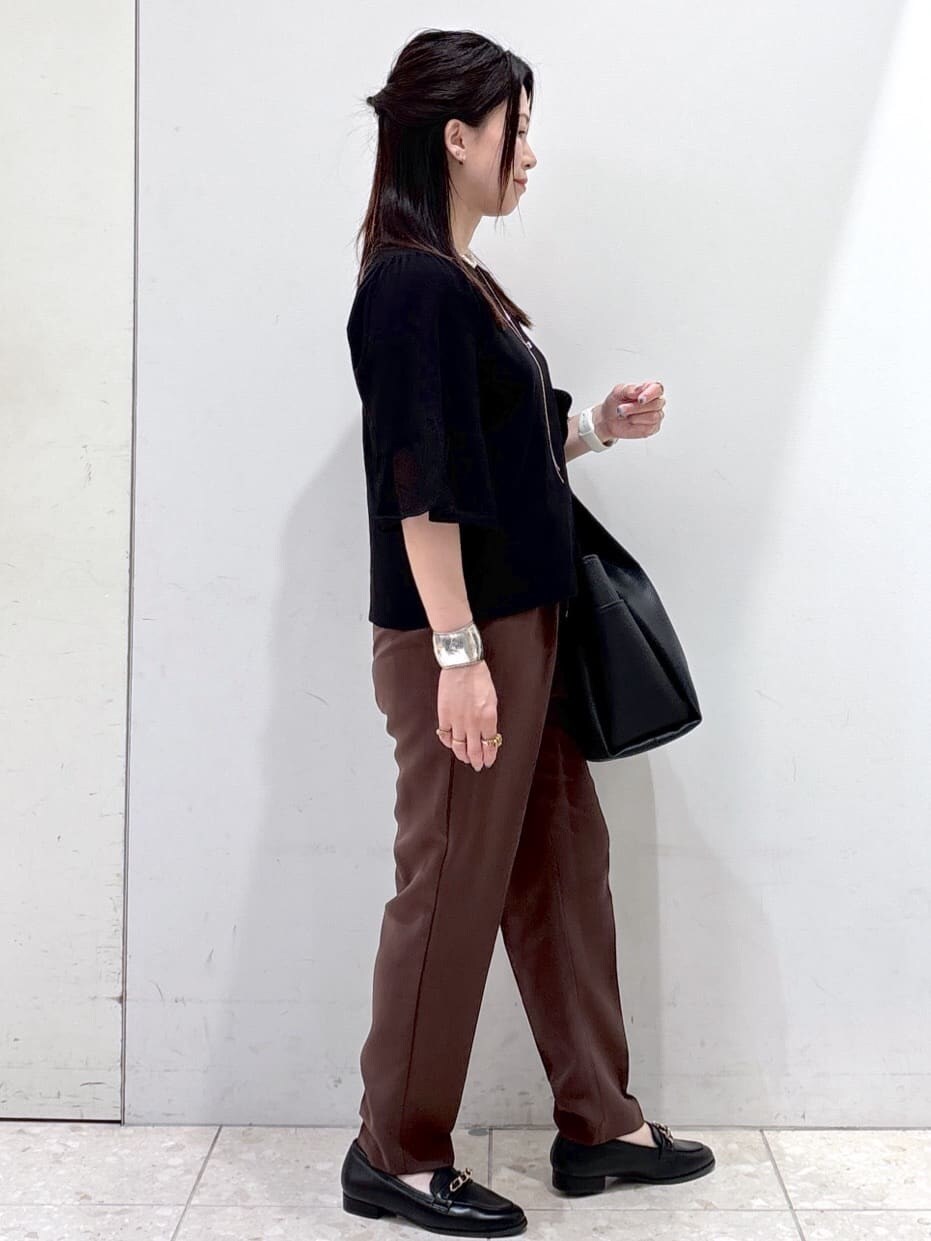 ブラック系のニット/セーター、ブラウン系のその他パンツ、ブラック系のトートバッグを着用したレディースの夏コーディネートの7枚目の写真