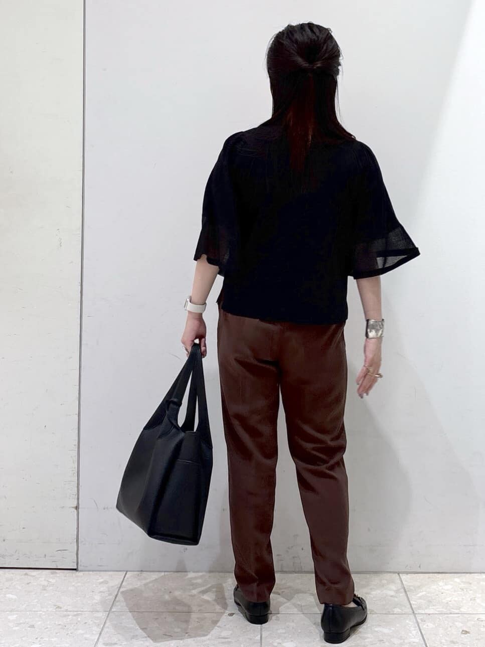 ブラック系のニット/セーター、ブラウン系のその他パンツ、ブラック系のトートバッグを着用したレディースの夏コーディネートの3枚目の写真