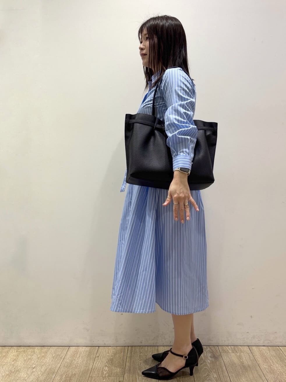 ブラック系のパンプス、ブルー系のワンピース、ブラック系のトートバッグを着用したレディースの春コーディネートの2枚目の写真