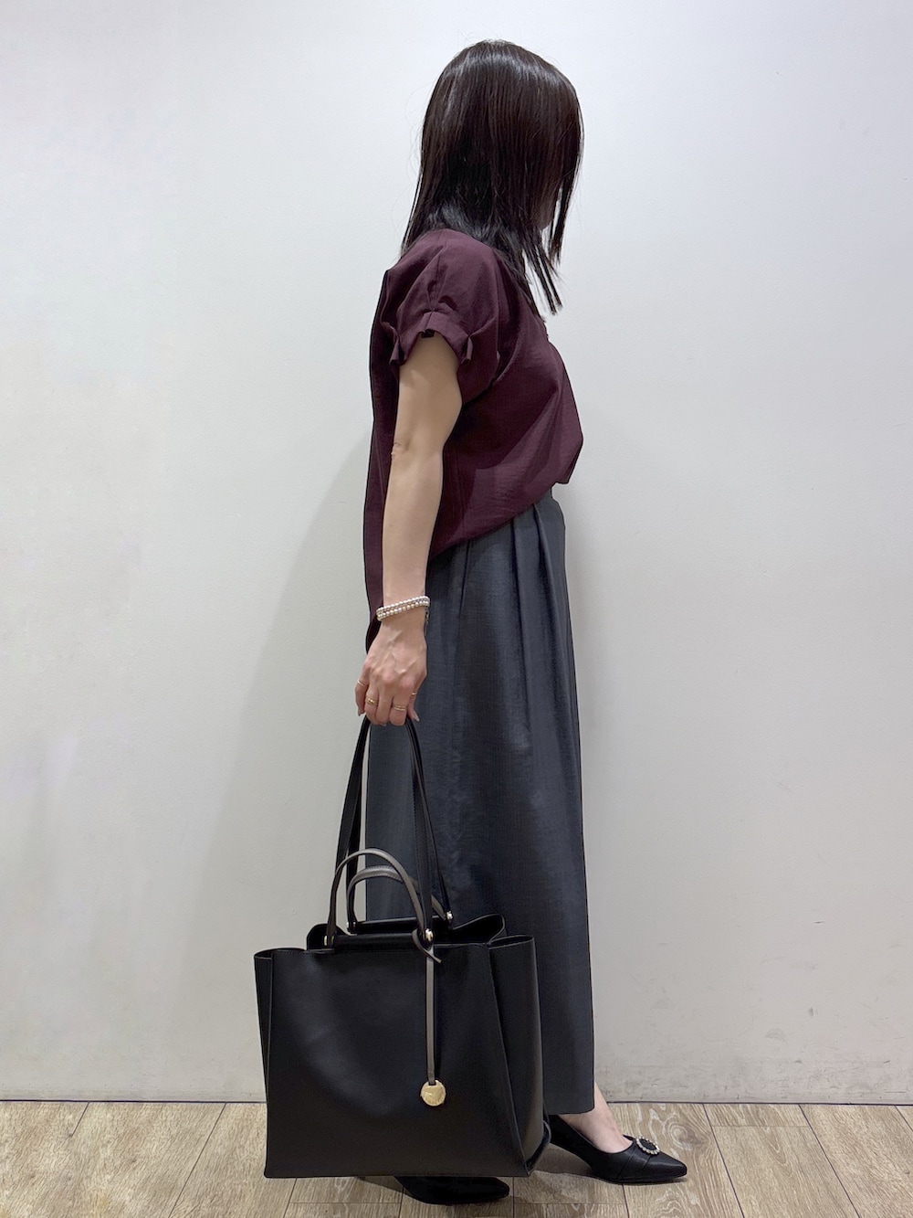 レッド系のシャツ/ブラウス、グレー系のその他パンツ、ブラック系のトートバッグを着用したレディースの夏コーディネートの2枚目の写真