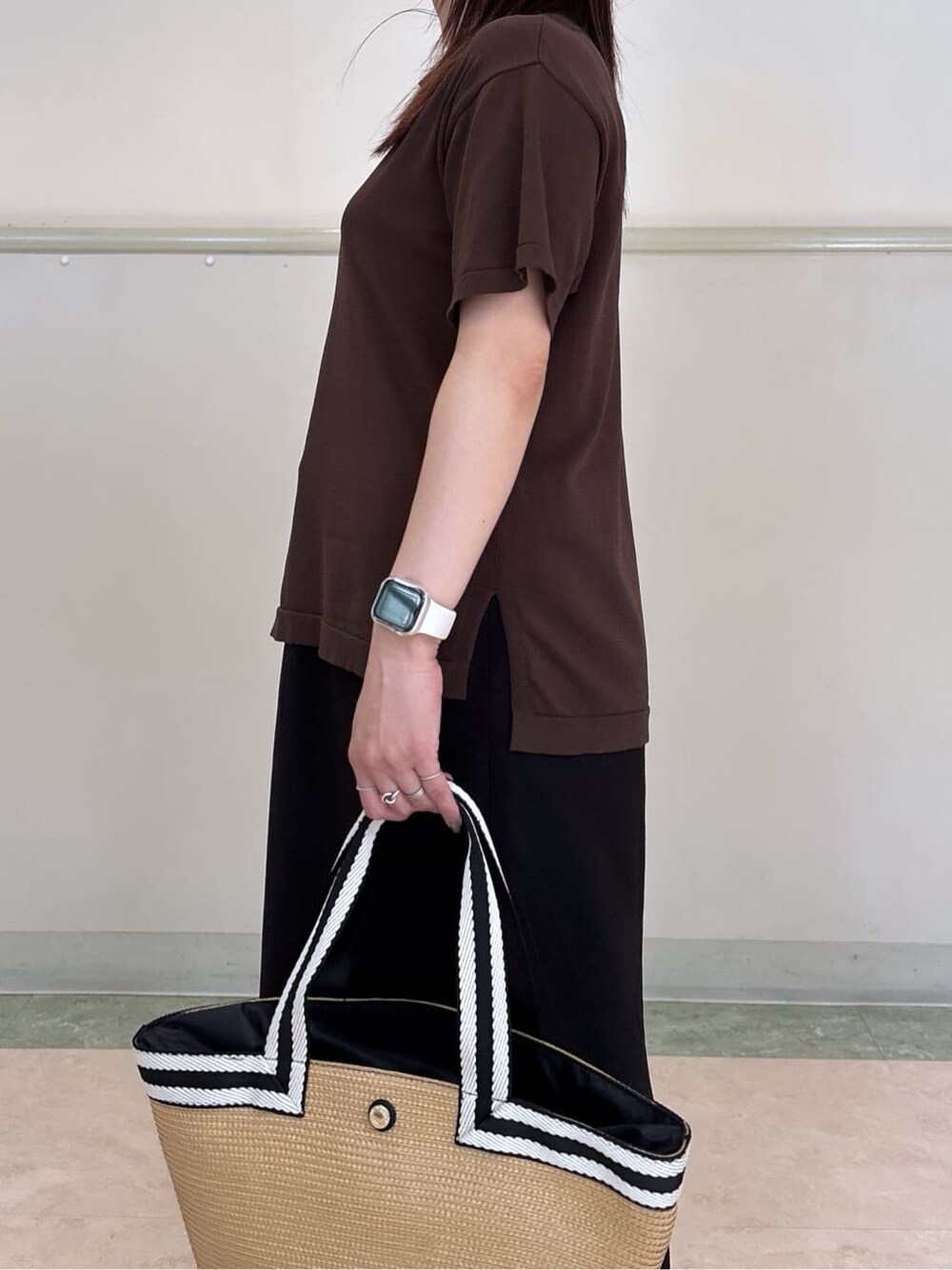 ブラウン系のニット/セーター、ブラック系のスカート、ベージュ系のトートバッグを着用したレディースの夏コーディネートの6枚目の写真