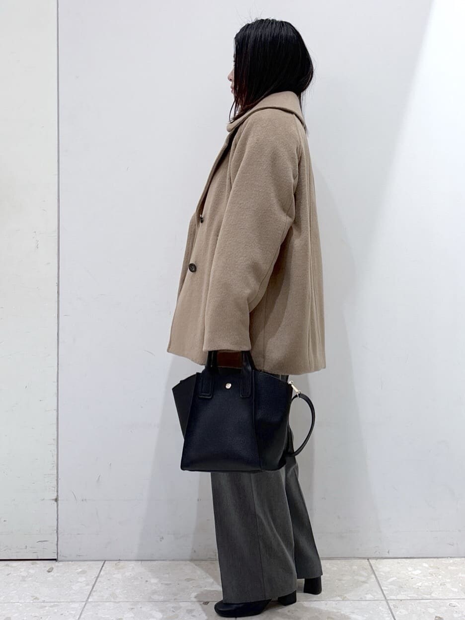 ベージュ系のピーコート、ブルー系のニット/セーター、グレー系のその他パンツを着用したレディースの冬コーディネートの4枚目の写真