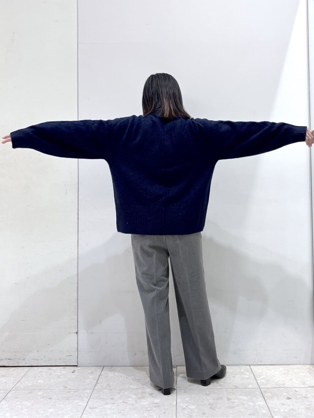 ブルー系のニット/セーター、グレー系のその他パンツ、ブラック系のショルダーバッグを着用したレディースの冬コーディネートの4枚目の写真
