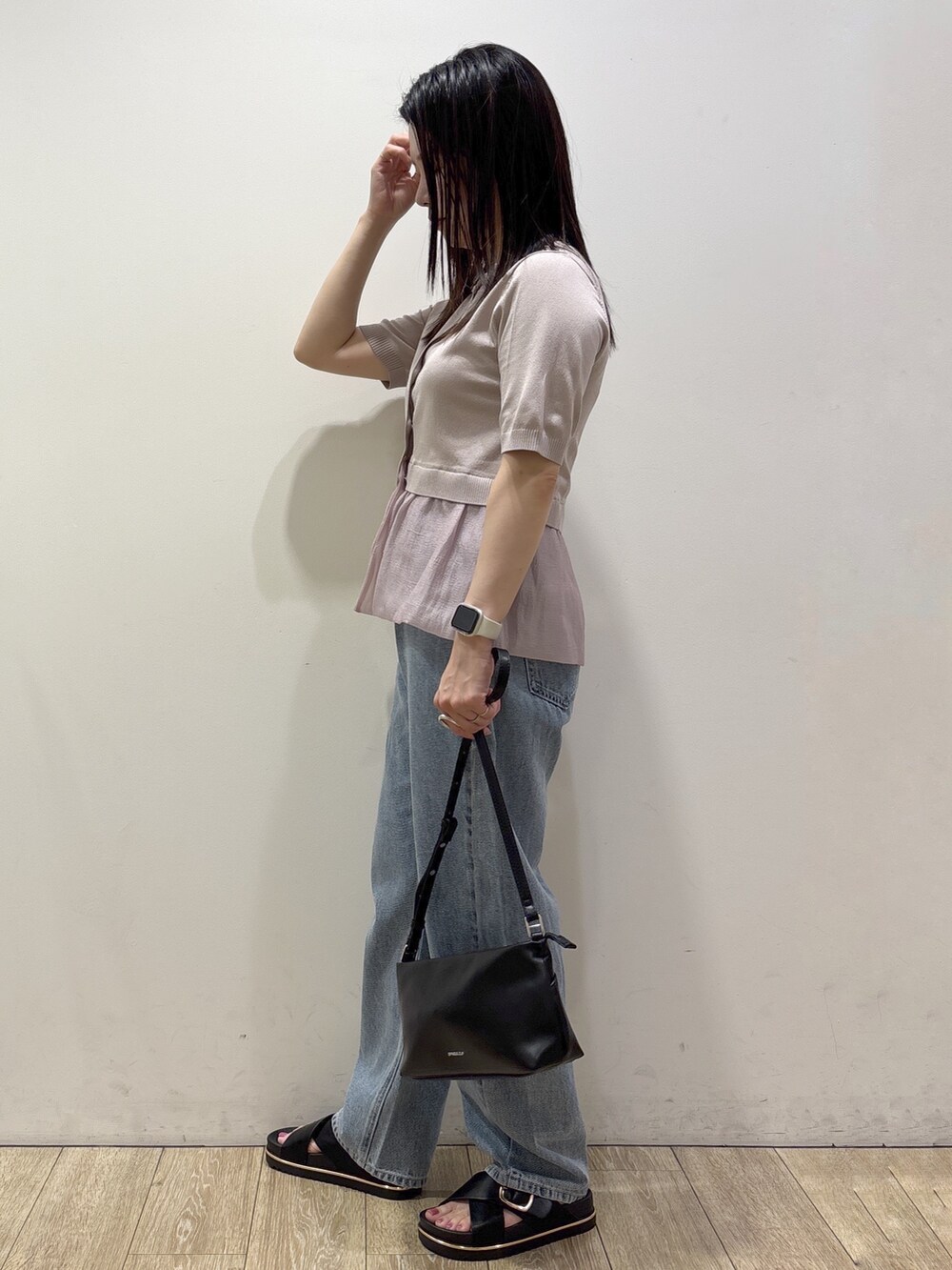 ベージュ系のカーディガン/ボレロ、ブルー系のデニムパンツ、ブラック系のショルダーバッグを着用したレディースの夏コーディネートの4枚目の写真