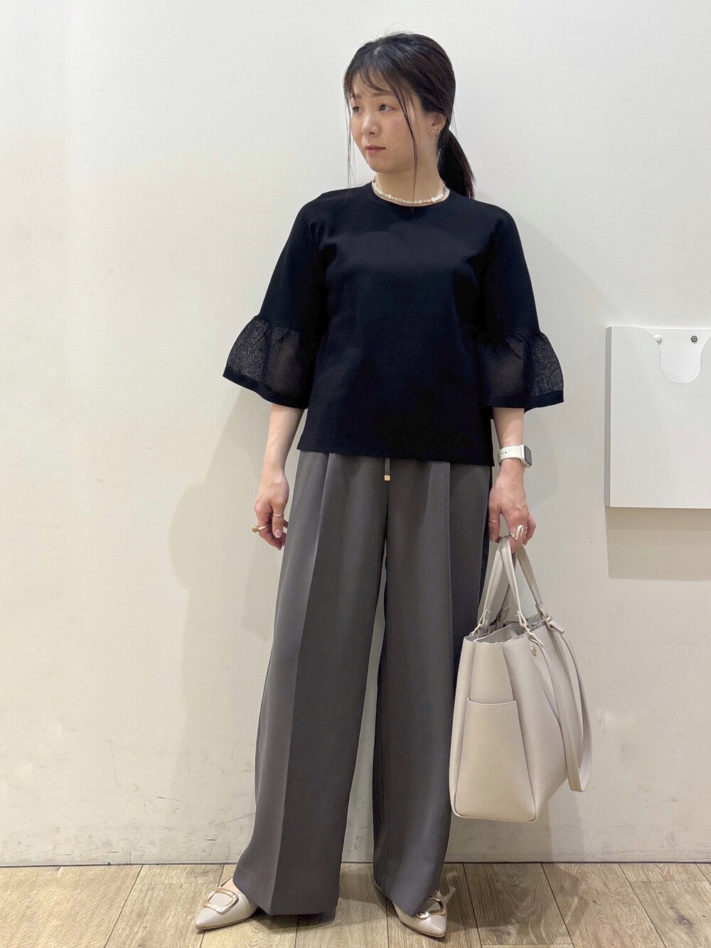 ベージュ系のパンプス、グレー系のカーディガン/ボレロ、ベージュ系のトートバッグを着用したレディースの春コーディネートの8枚目の写真