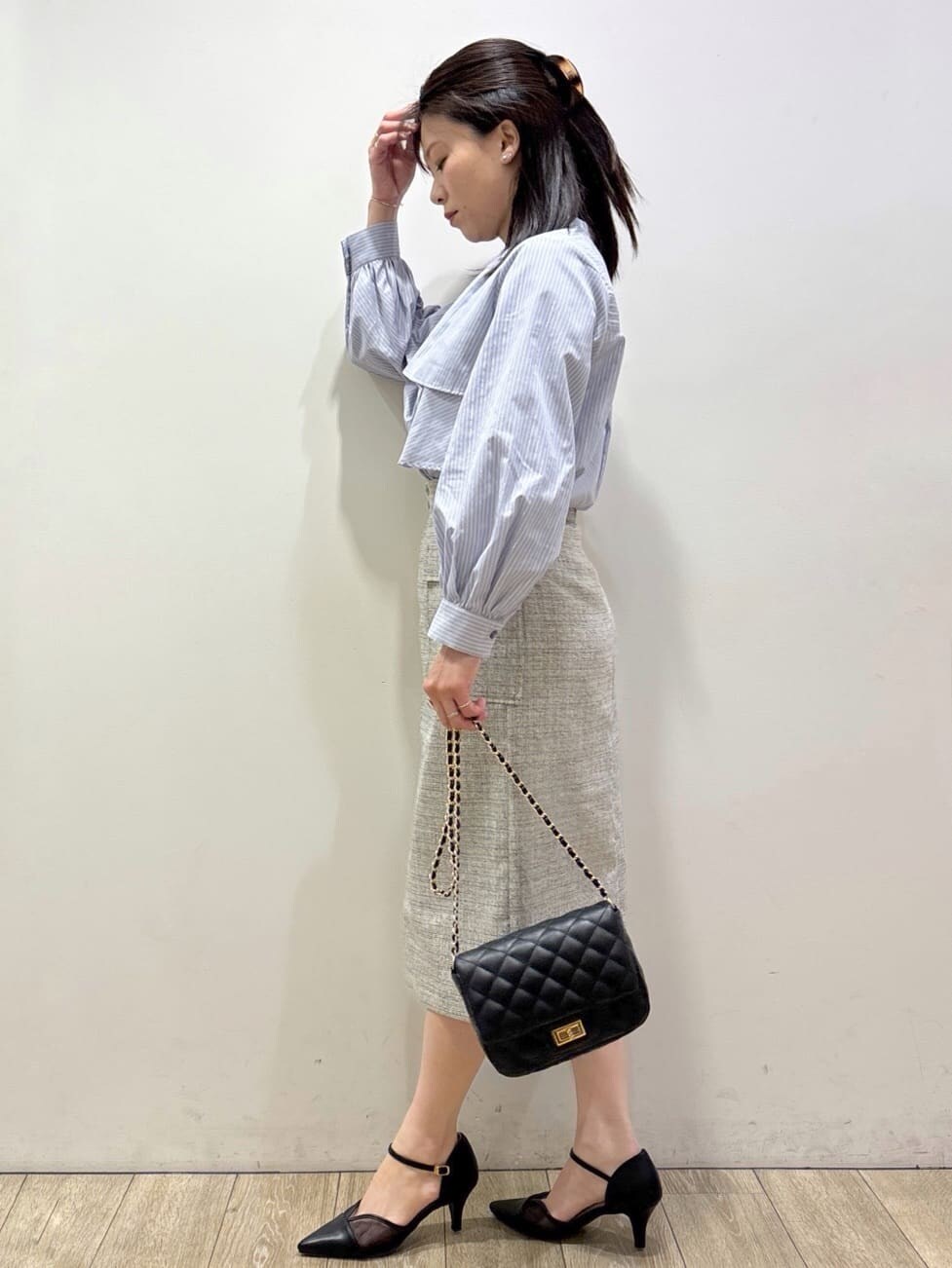 ブラック系のパンプス、ベージュ系のスカート、ブルー系のシャツ/ブラウスを着用したレディースの春コーディネートの4枚目の写真