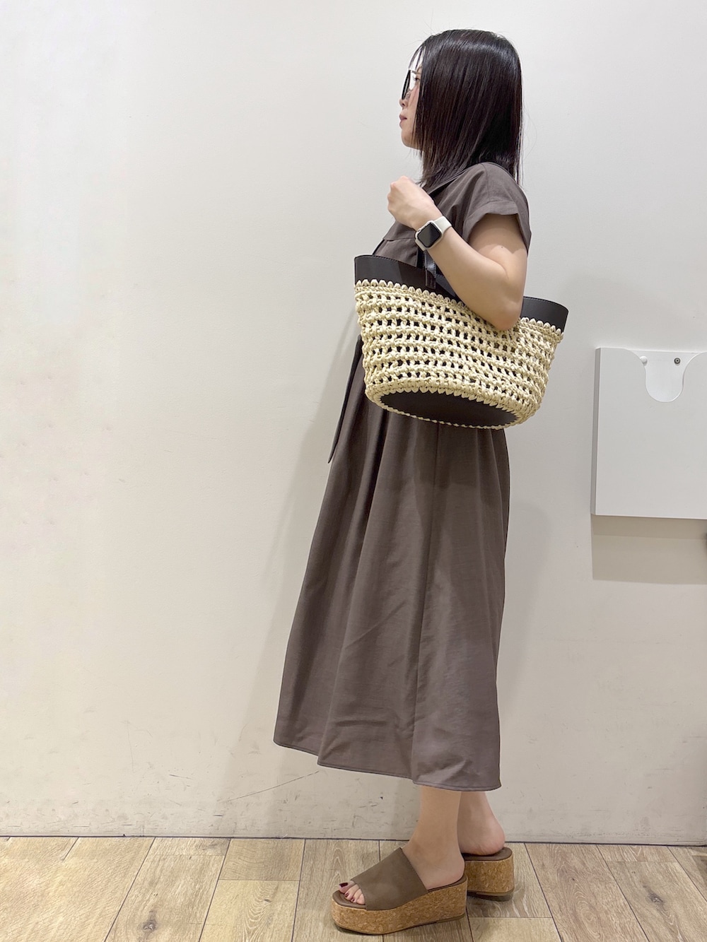 ブラウン系のワンピース、ブラウン系のトートバッグ、ベージュ系のサンダルを着用したレディースの夏コーディネートの2枚目の写真