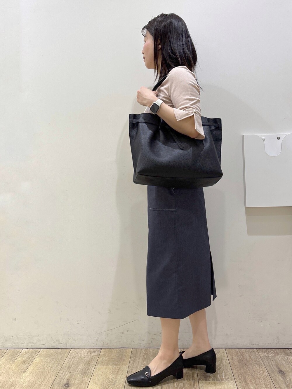 ブラック系のパンプス、ブラック系のトートバッグ、ブルー系のスカートを着用したレディースの春コーディネートの4枚目の写真