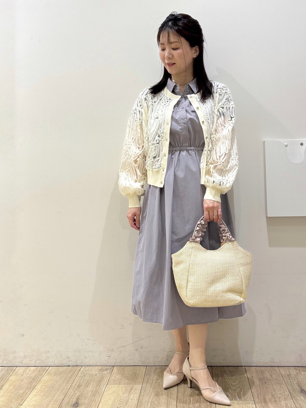 ホワイト系のカーディガン/ボレロ、グレー系のワンピース、ベージュ系のトートバッグを着用したレディースの春コーディネートの5枚目の写真