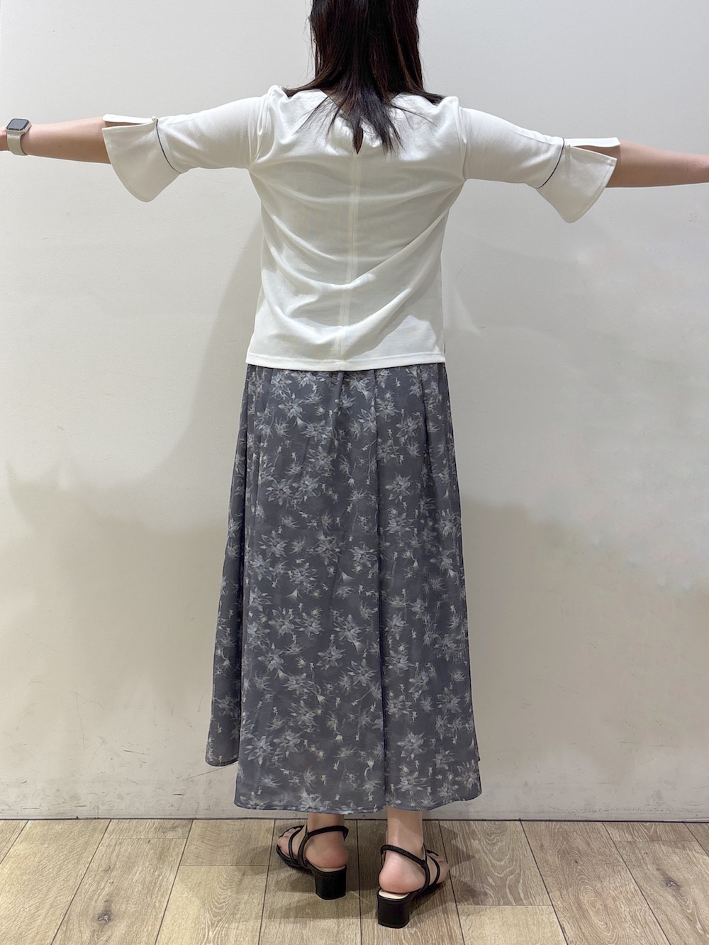 ブラック系のサンダル、ホワイト系のTシャツ/カットソー、グレー系のスカートを着用したレディースの春コーディネートの8枚目の写真