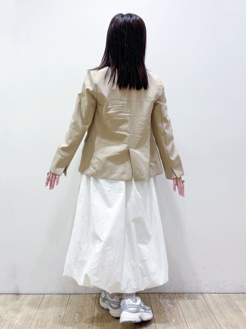 ホワイト系のTシャツ/カットソー、ベージュ系のテーラードジャケット、ホワイト系のスカートを着用したレディースの春コーディネートの3枚目の写真