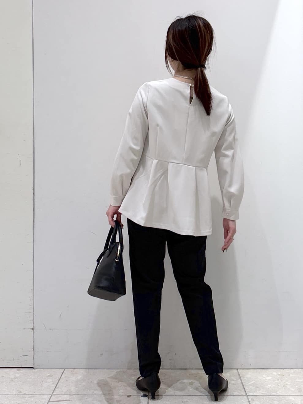 ベージュ系のシャツ/ブラウス、ブラック系のその他パンツ、ブラック系のハンドバッグを着用したレディースの冬コーディネートの2枚目の写真
