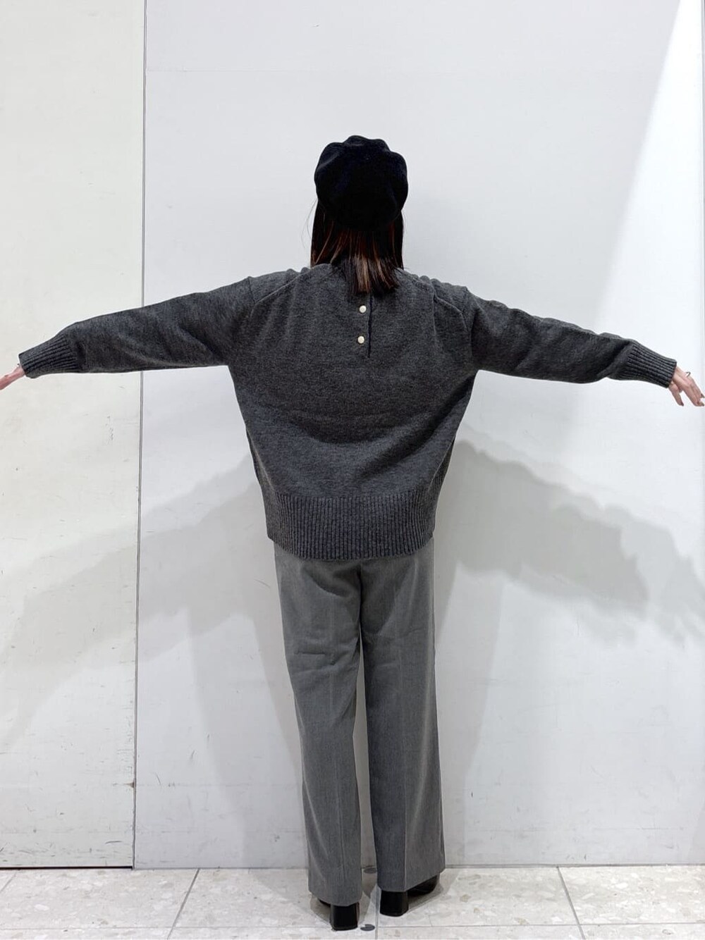 グレー系のニット/セーター、ホワイト系のTシャツ/カットソー、グレー系のその他パンツを着用したレディースの冬コーディネートの4枚目の写真