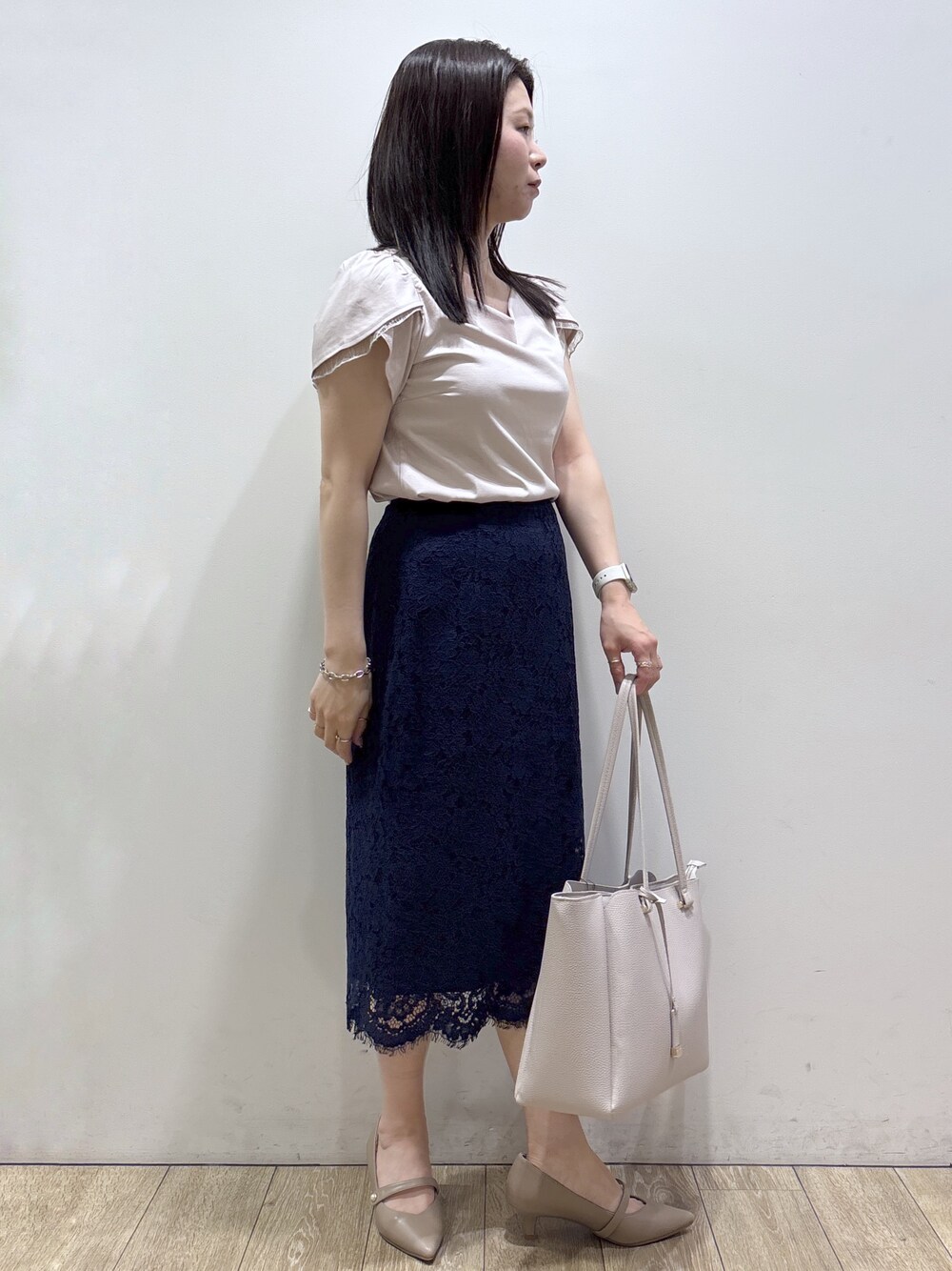 ベージュ系のTシャツ/カットソー、グレー系のトートバッグ、ベージュ系のパンプスを着用したレディースの夏コーディネートの4枚目の写真