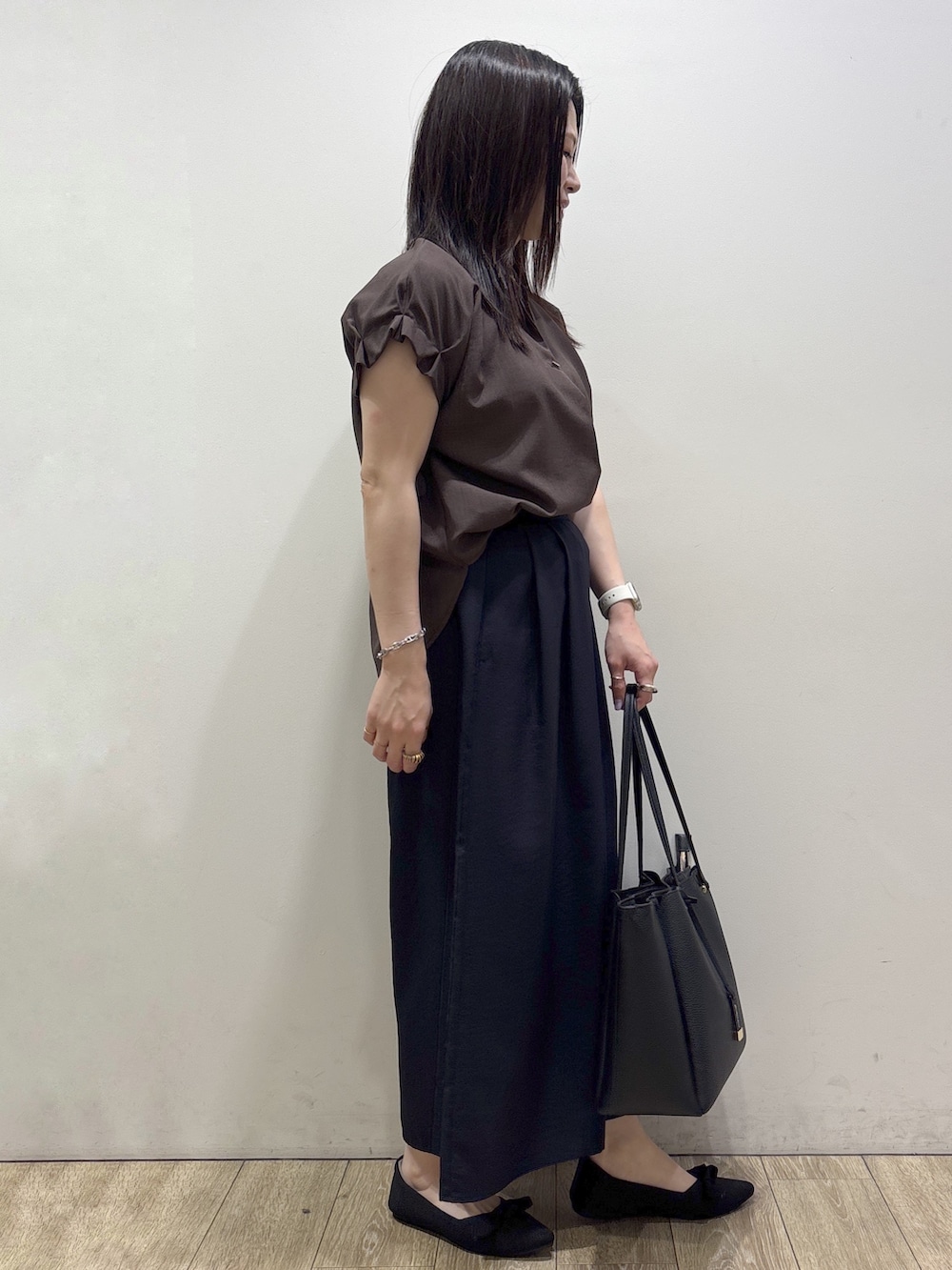 ブラウン系のシャツ/ブラウス、ブルー系のその他パンツ、ブラック系のトートバッグを着用したレディースの夏コーディネートの2枚目の写真