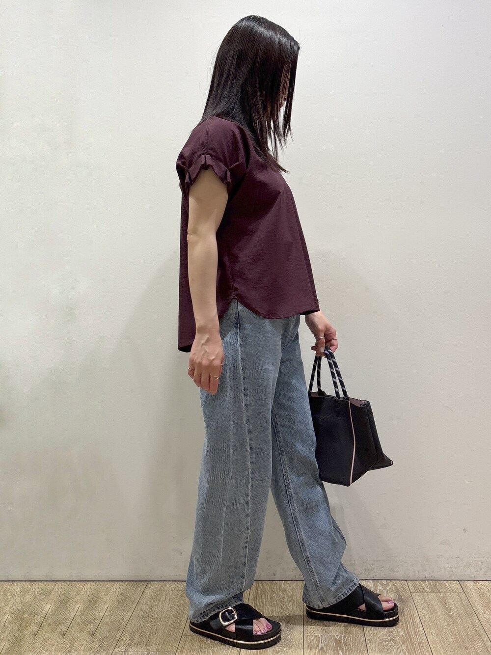 レッド系のシャツ/ブラウス、ブルー系のデニムパンツ、グレー系のトートバッグを着用したレディースの夏コーディネートの2枚目の写真