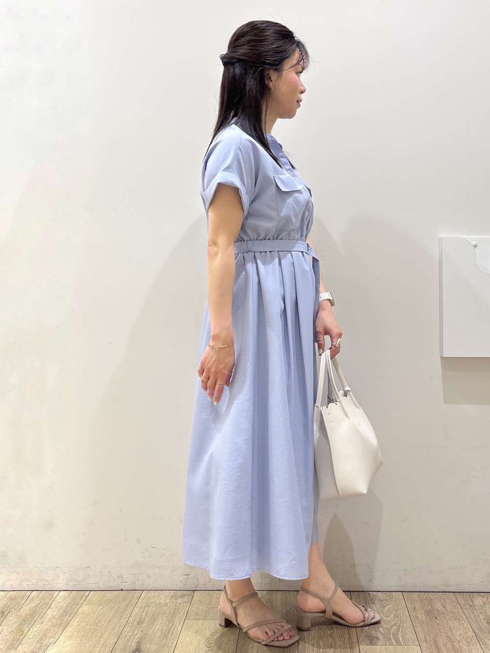 ブルー系のワンピース、ホワイト系のトートバッグ、ベージュ系のサンダルを着用したレディースの春コーディネートの2枚目の写真
