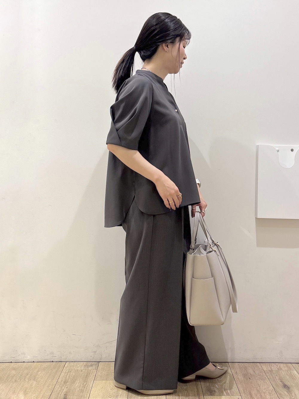 ベージュ系のパンプス、グレー系のカーディガン/ボレロ、ベージュ系のトートバッグを着用したレディースの春コーディネートの2枚目の写真