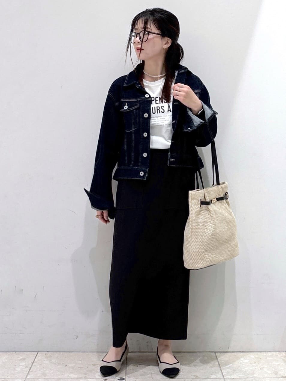 ブルー系のデニムジャケット、ホワイト系のTシャツ/カットソー、ブラック系のスカートを着用したレディースの春コーディネートの5枚目の写真
